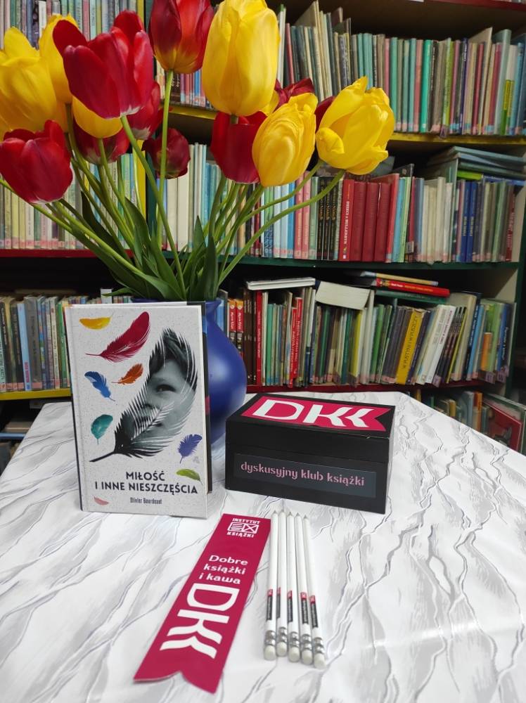 Na zdjęciu bukiet tulipanów w wazonie i wyeksponowane egzemplarze omawianej w klubie książki.