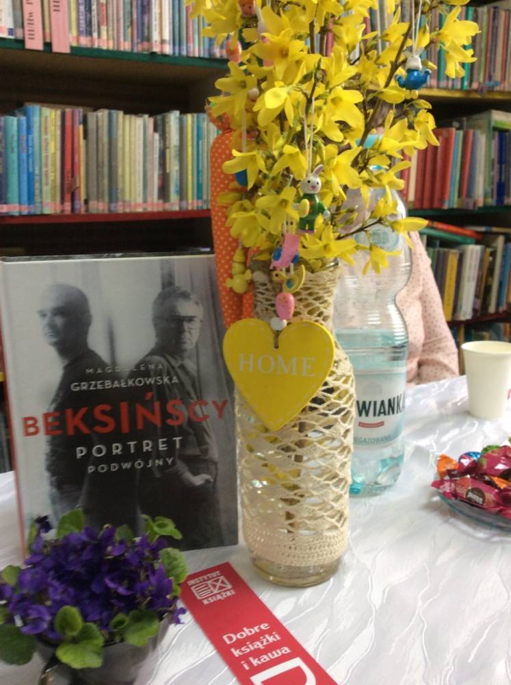 Na zdjęciu wyeksponowany, obok wiosennych gałązek w dzbanku wolumin książki omawianej w klubie.